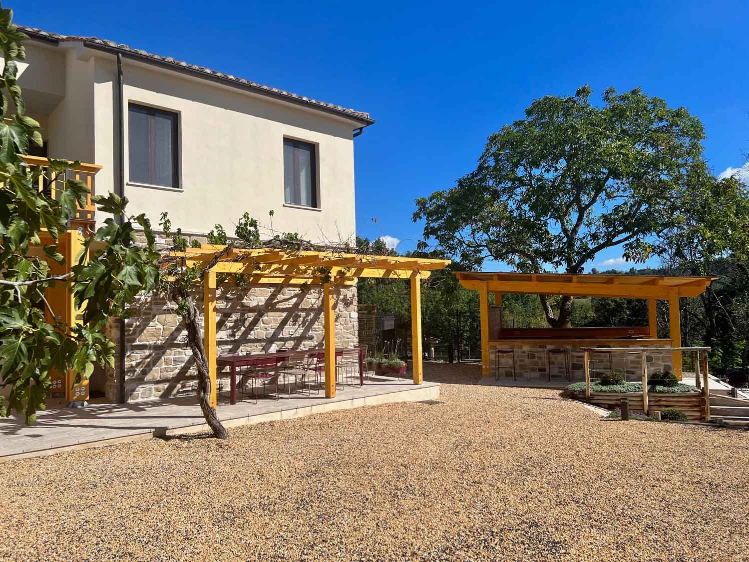 Communal outdoor kitchen and long dining table at Colpo di Fortuna